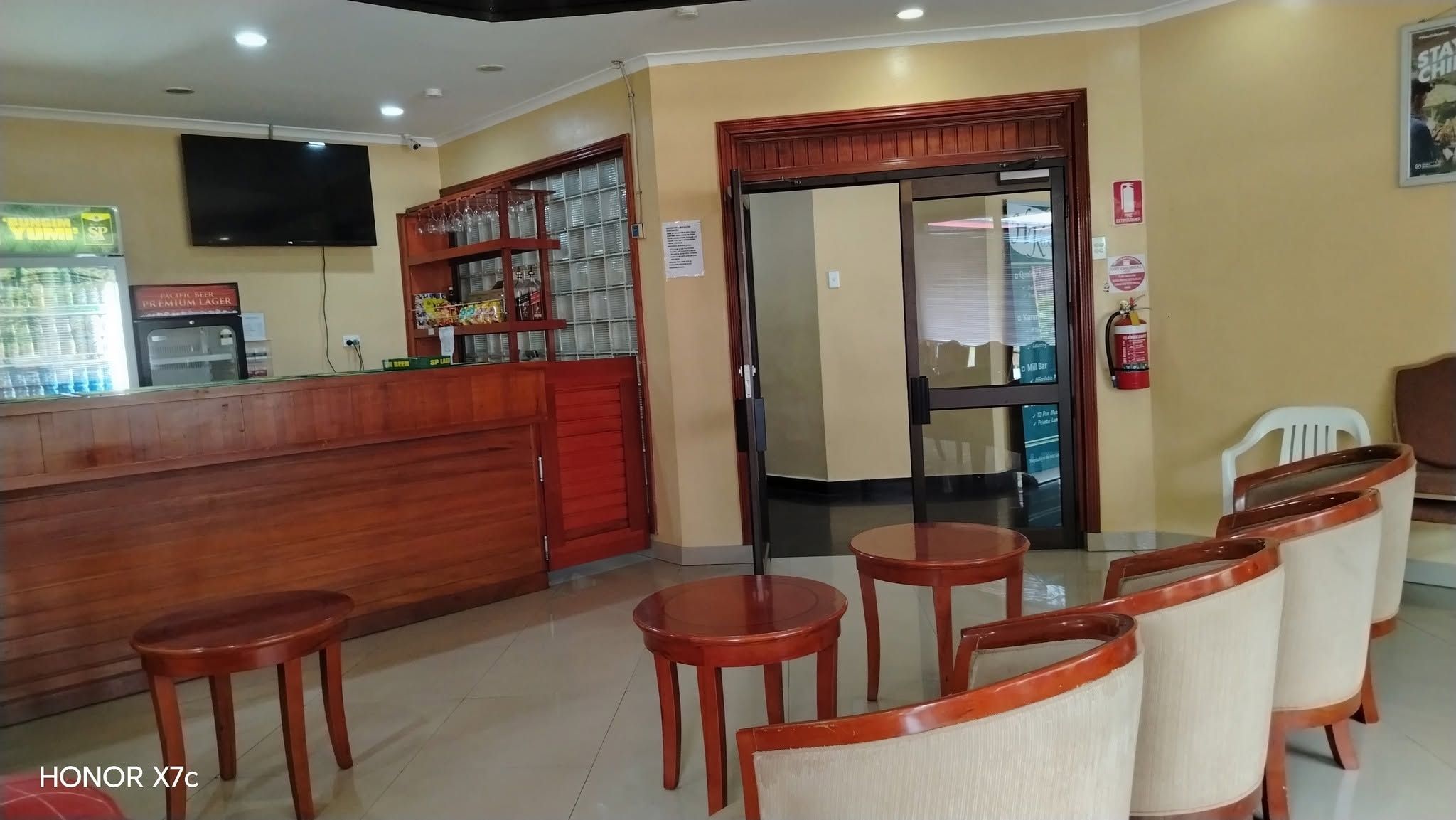 A bar area and lounge seating with timber tables and upholstered chairs.
