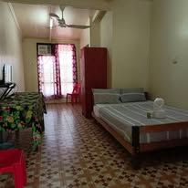 Private bedroom with a queen bed, dining table, and ceiling fan