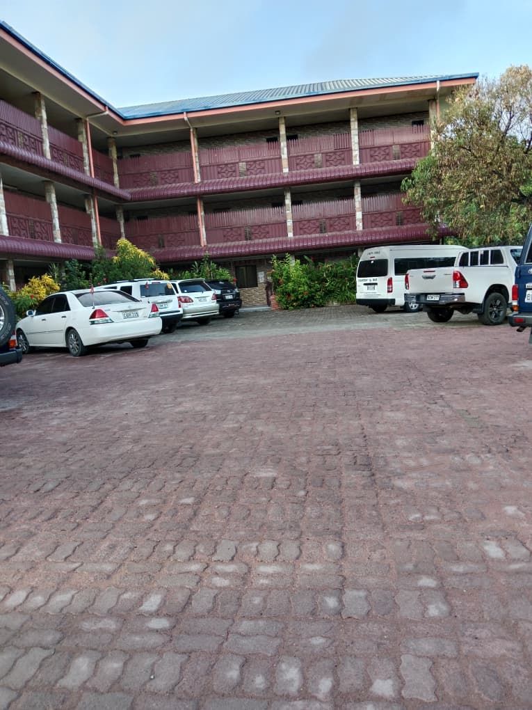 Multi-story lodge building with guest parking area in front.