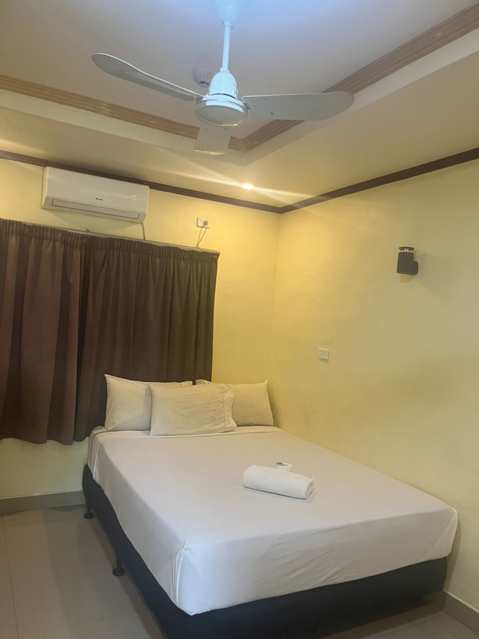 Guest bedroom with double bed, air conditioning, and ceiling fan.