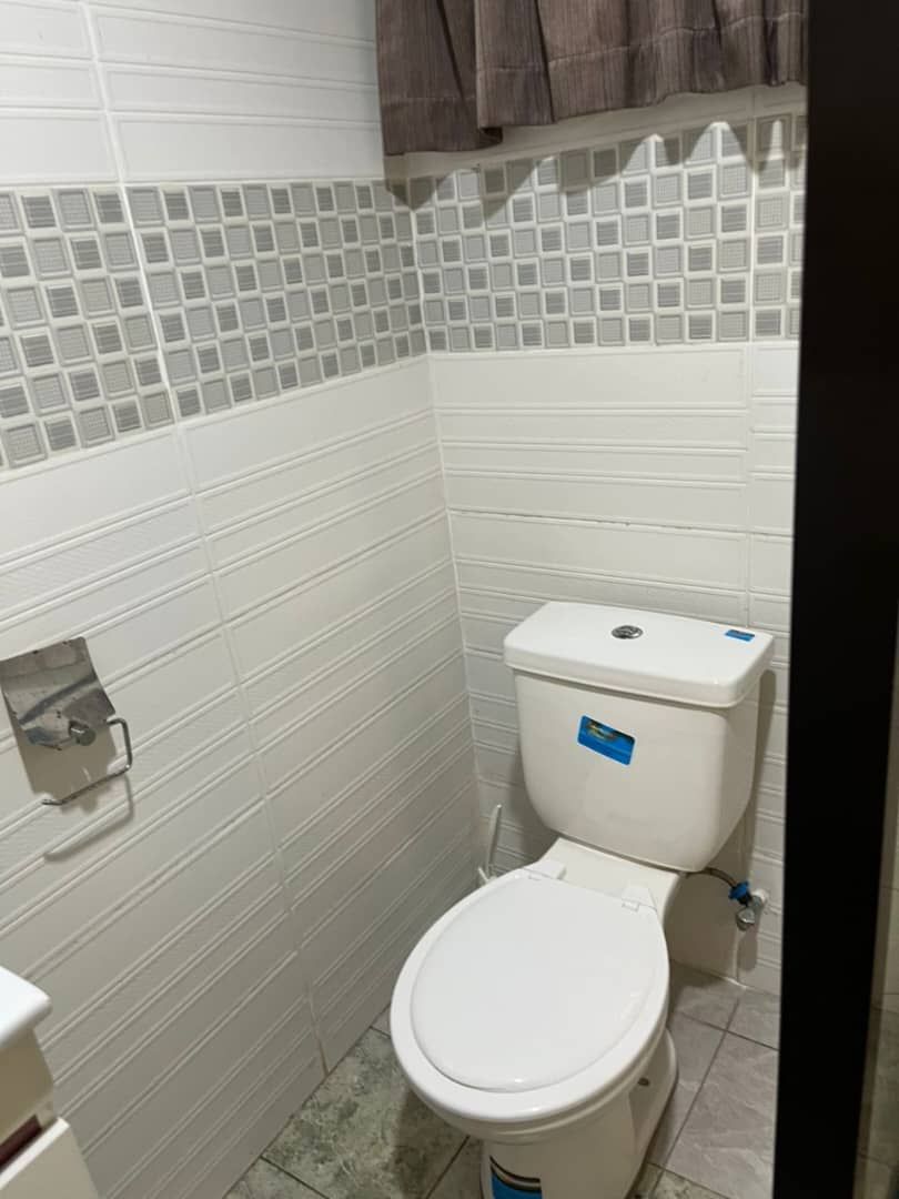 Clean bathroom interior with white toilet and tiled walls.