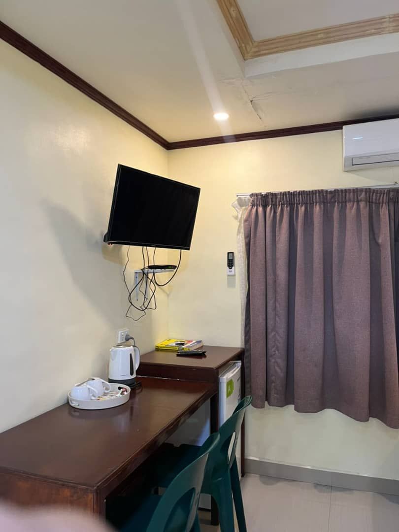 Work desk area with wall-mounted television and tea station.