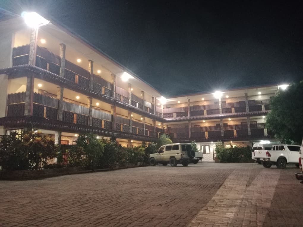 Night view of the lodge building and illuminated parking courtyard.