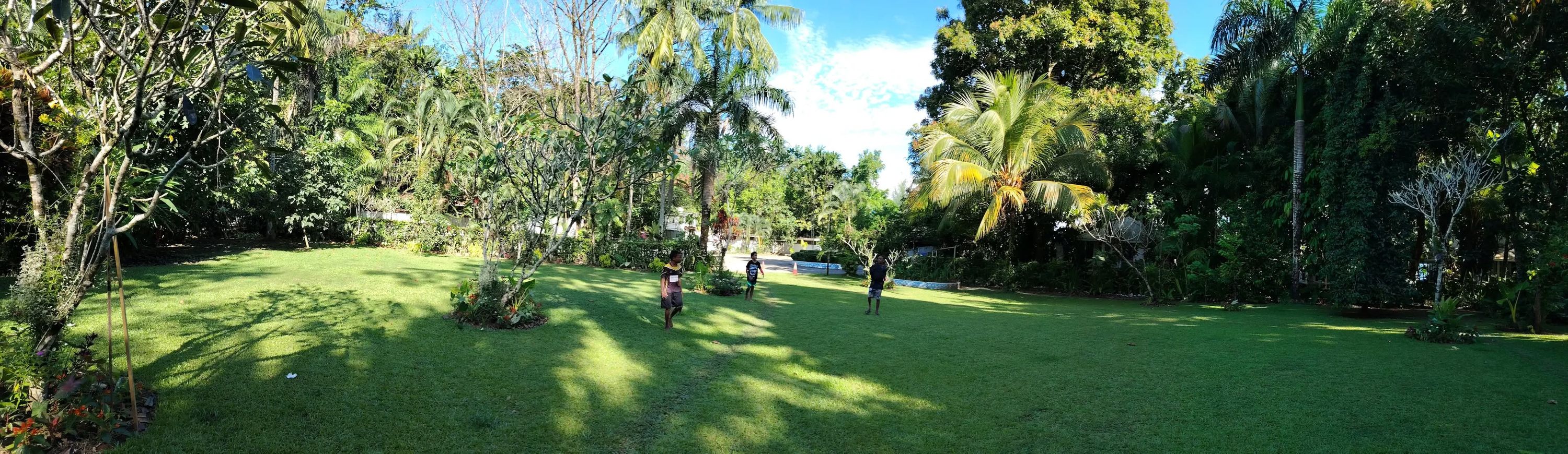 Wide panoramic view of the landscaped garden grounds and palm trees