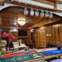 Indoor bar area with hanging glassware and wooden paneling.