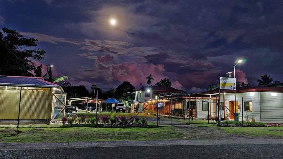 Wide view of the lodge compound under a moonlit sky.