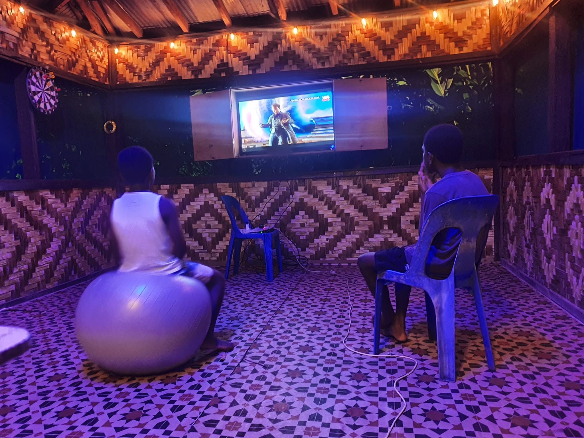 Indoor lounge area with woven walls and a television for guest entertainment.