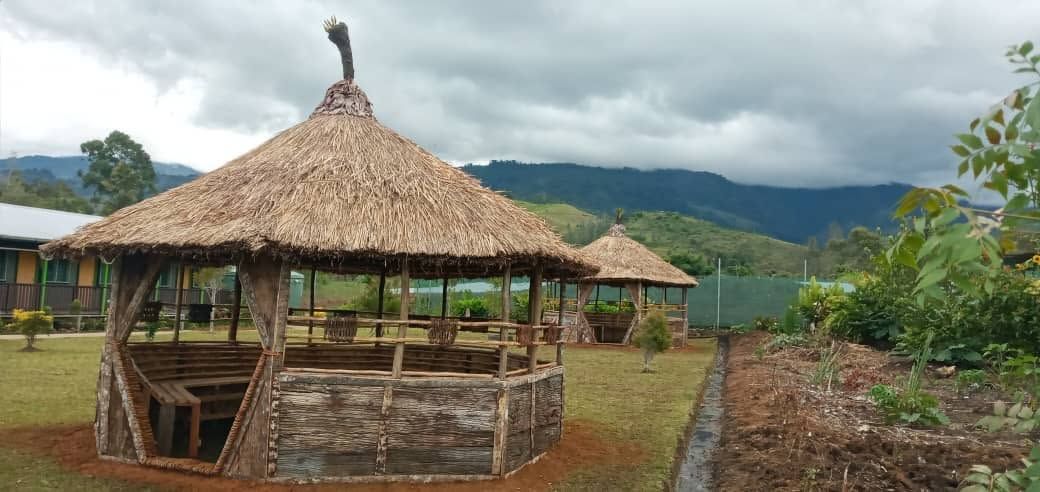 Traditional thatched-roof gazebos overlooking the mountains.