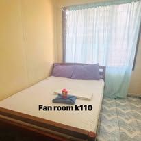 Guest bedroom with a double bed, patterned tile flooring and light curtains.