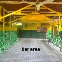 Spacious bar and seating area with yellow and green wooden structural elements.