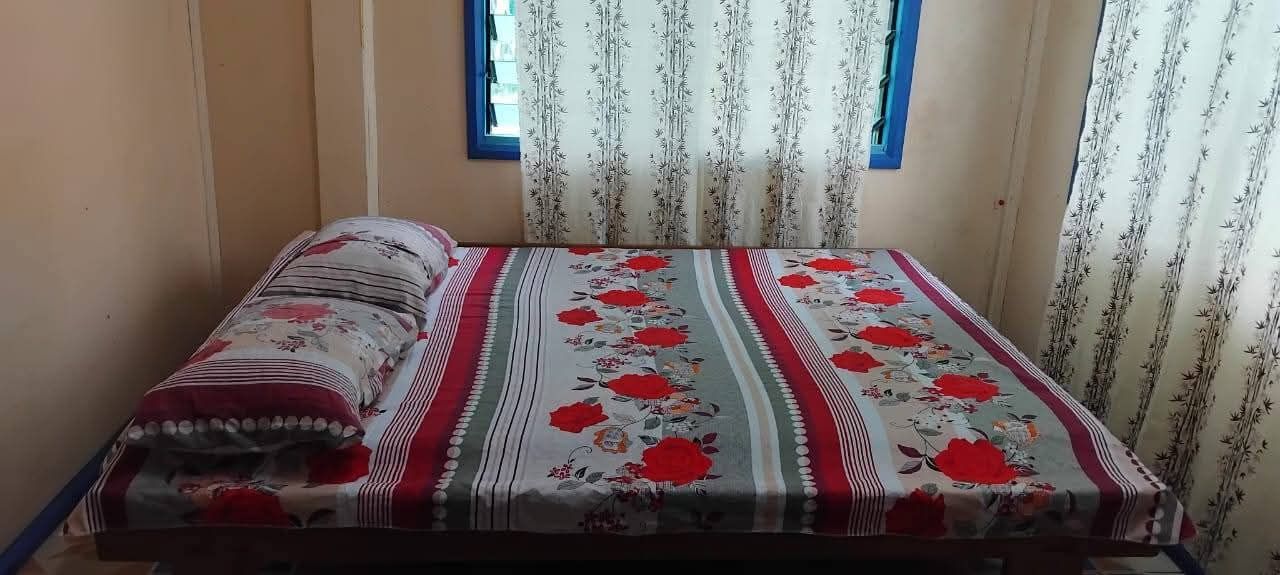 Bedroom featuring a floral print bedspread and bamboo-patterned curtains.