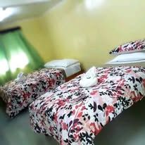 Two single beds featuring floral bedspreads and white towels.