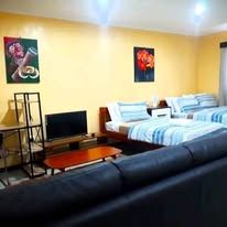 Guest suite with television, seating area, and blue striped bedding.