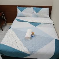 Double bed with blue and white geometric patterned bedding.
