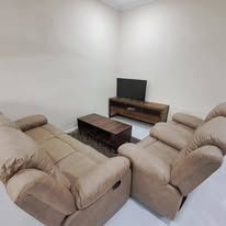 Living area with beige sofas, a coffee table, and television.