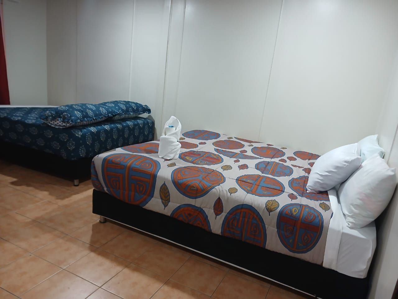 Guest room featuring two beds with colorful patterned comforters