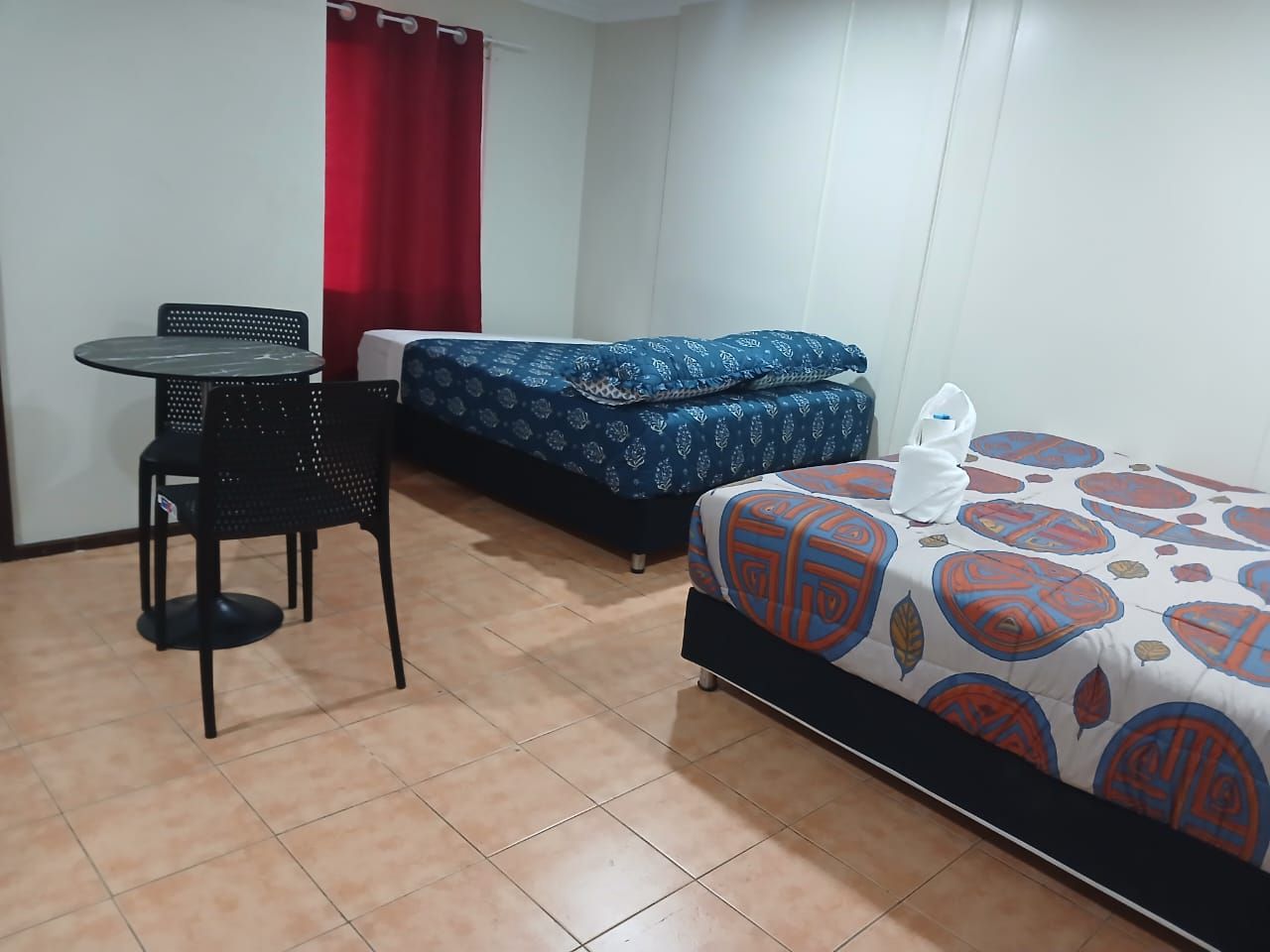 Spacious twin room with a small dining table and chairs