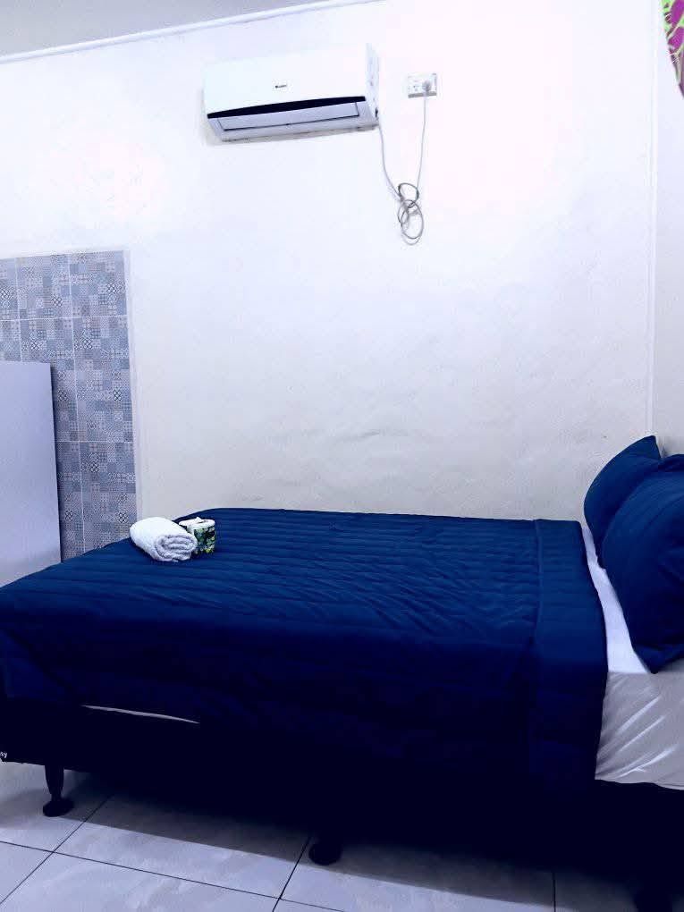 Guest bedroom featuring a queen bed with blue linens and wall-mounted air conditioning.