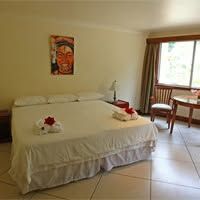 Hotel guest room with white linens and tiled flooring