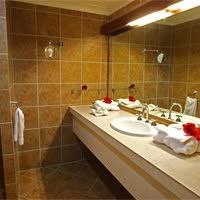 Tiled bathroom featuring a large vanity and mirrors
