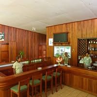 Wooden hotel bar area with stool seating and staff