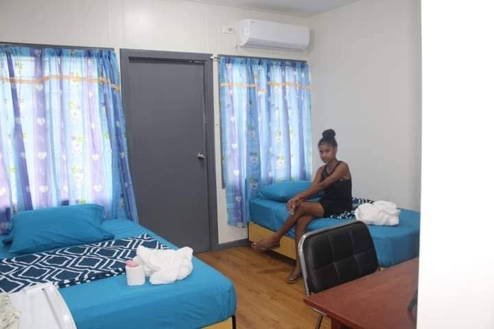 Twin bedroom featuring air conditioning and wooden-style flooring.