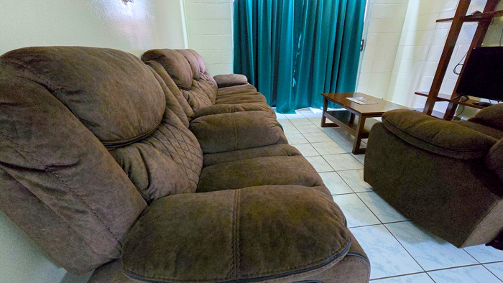 Living area featuring brown reclining sofas and a wooden coffee table.