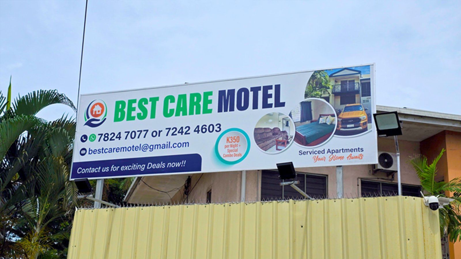The motel identification signboard displayed above the security fence.