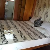 Hotel bed featuring music-themed linens and patterned wallpaper.