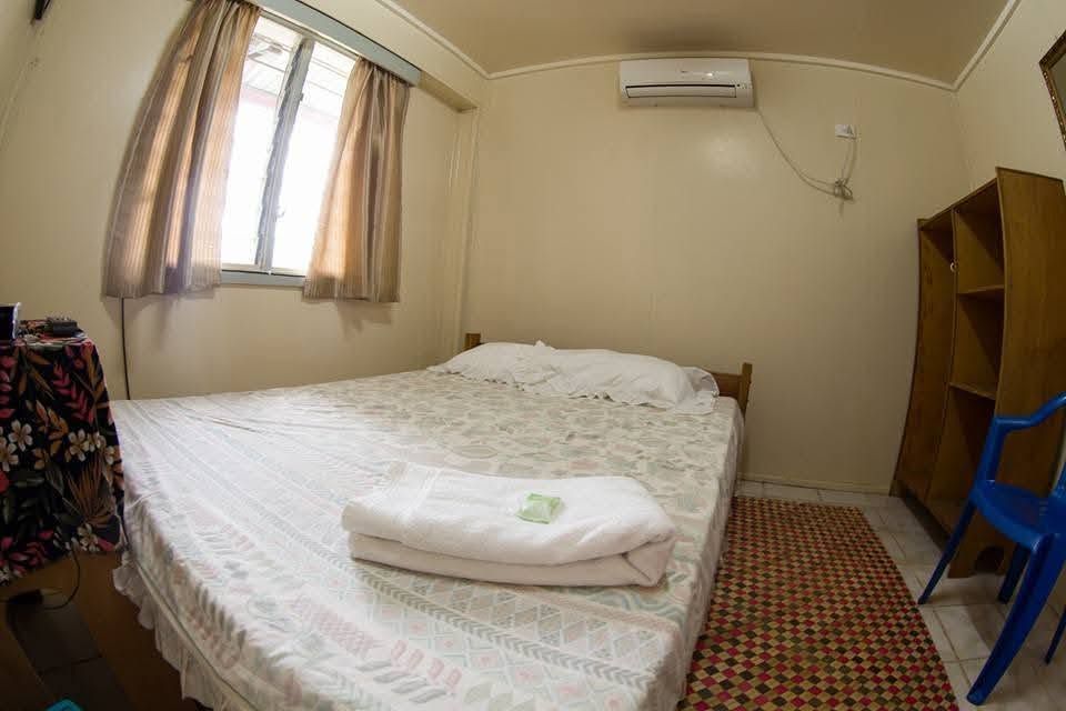 Self-contained guest room with air conditioning and wooden shelving unit.