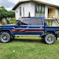 A blue off-road utility vehicle parked on the grass in front of the lodge.