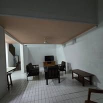 Shared living room area with dark wooden sofa set and a television unit.