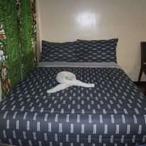 Close-up of a double bed with patterned linens and decorative towel arrangement.