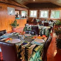 Indoor restaurant area with set dining tables and wood-paneled walls.
