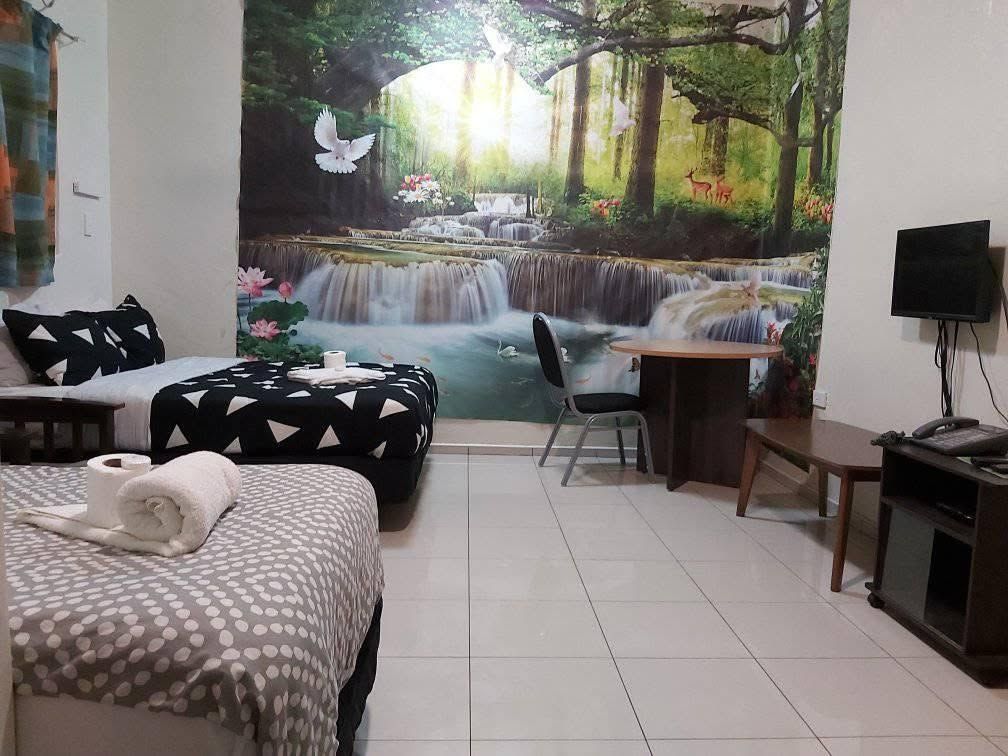 Guest room with waterfall wall mural, small table, and television.