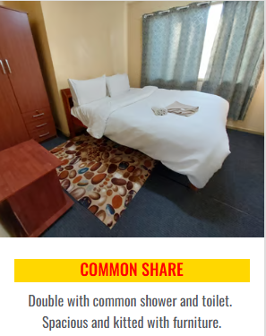 Double bed with white linens, wooden wardrobe, and patterned rug.