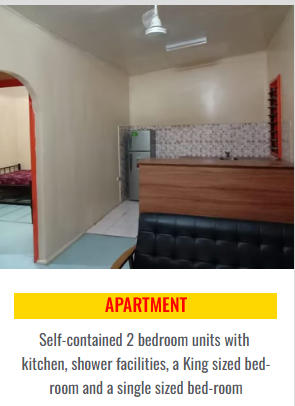 Apartment living space with kitchenette facility and view of the bedroom.