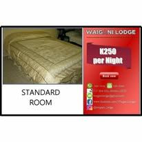 Standard guest bedroom with simple bedding and functional furniture.