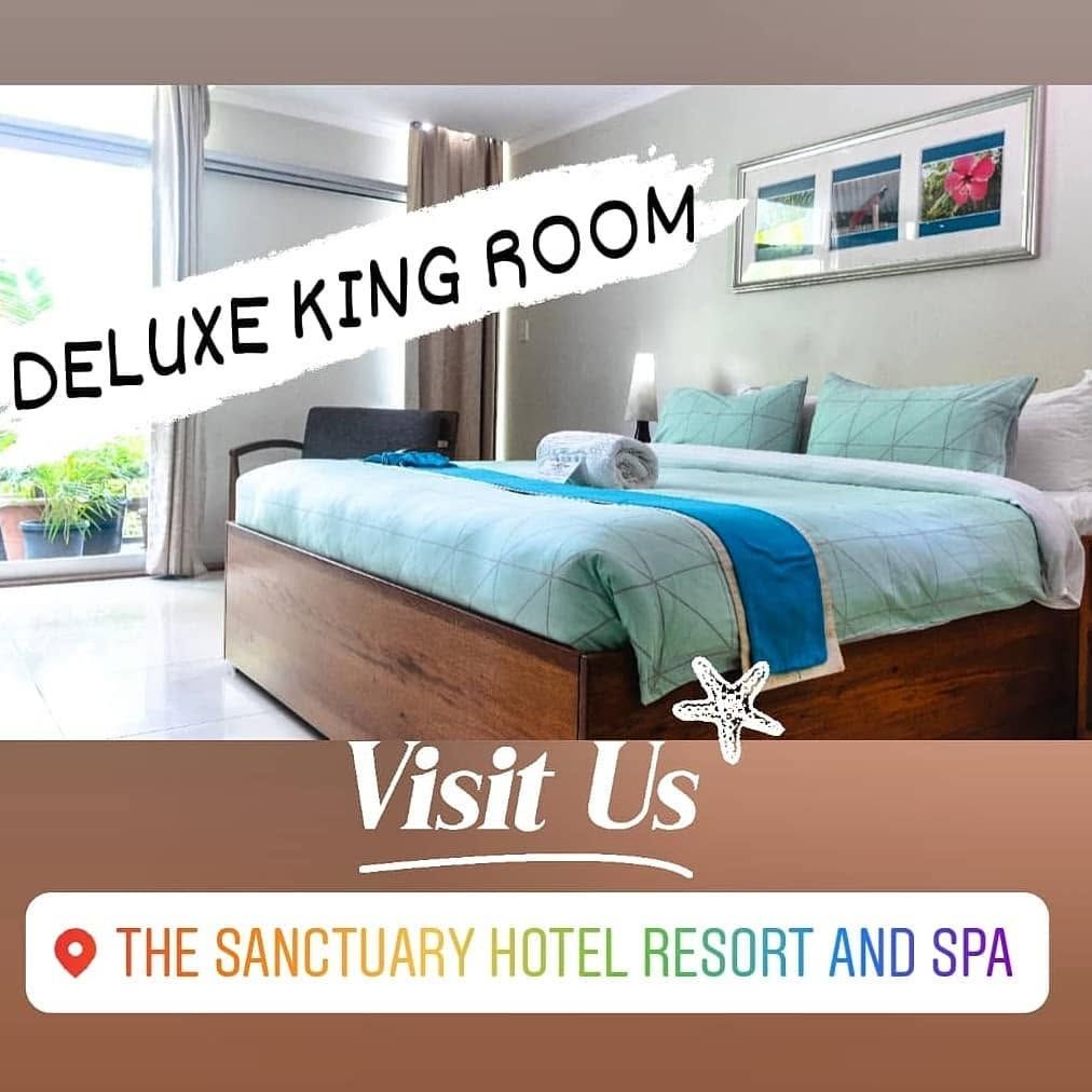 Deluxe King Room with patterned bedding and sliding door access.