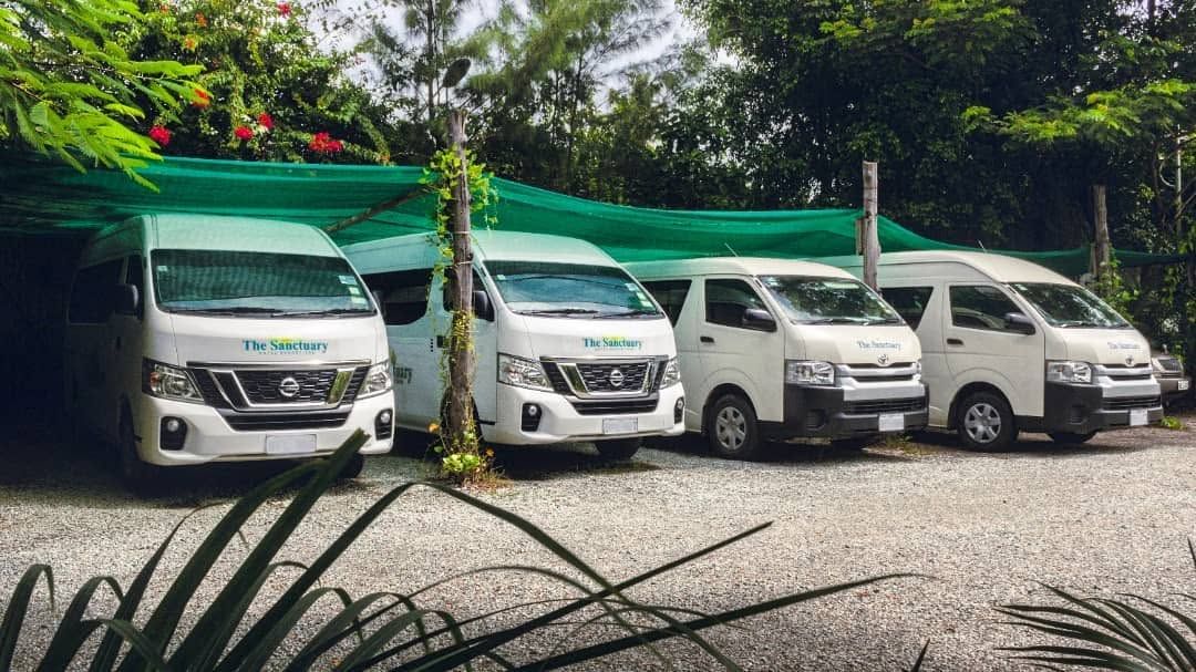 Row of sanctuary hotel resort and spa branded shuttle vans.