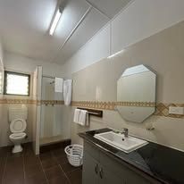 Clean bathroom featuring a modern vanity, mirror, toilet, and walk-in shower.