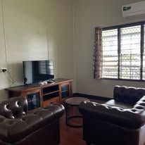 Living area with tufted leather armchairs and flat-screen television.