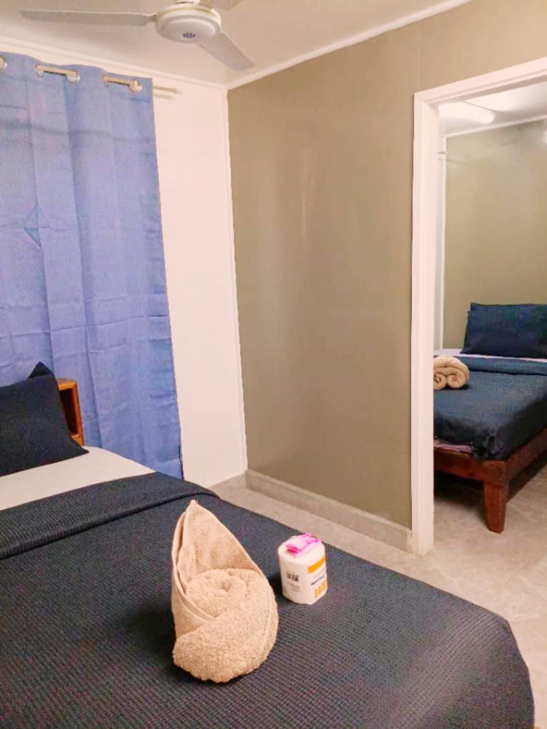 View through a doorway showing matched bedding and towels in two rooms.