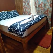 Neat bed with patterned pillows and patterned runner.