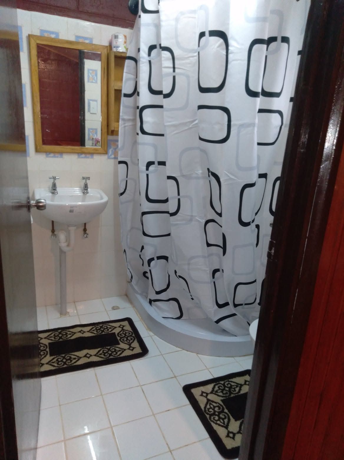 Bathroom featuring a pedestal sink and a walk-in shower.