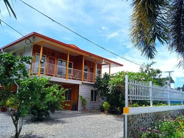 Two-story lodge building with timber balconies and gravel driveway