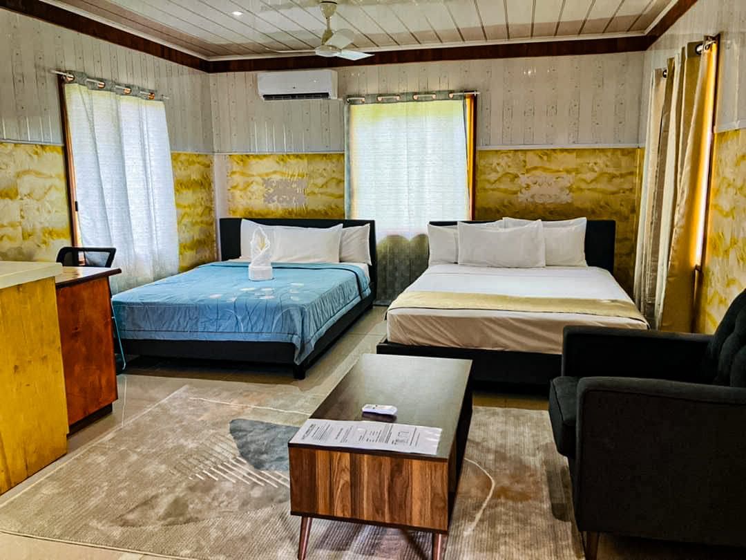 Spacious guest room featuring two large beds and a living area