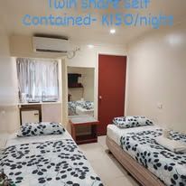Twin share room with two single beds and air conditioning units