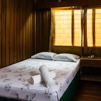 Bedroom with wood-paneled walls and a bed featuring shell-patterned linens.