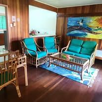 Common living area with cane furniture and bright blue upholstery.